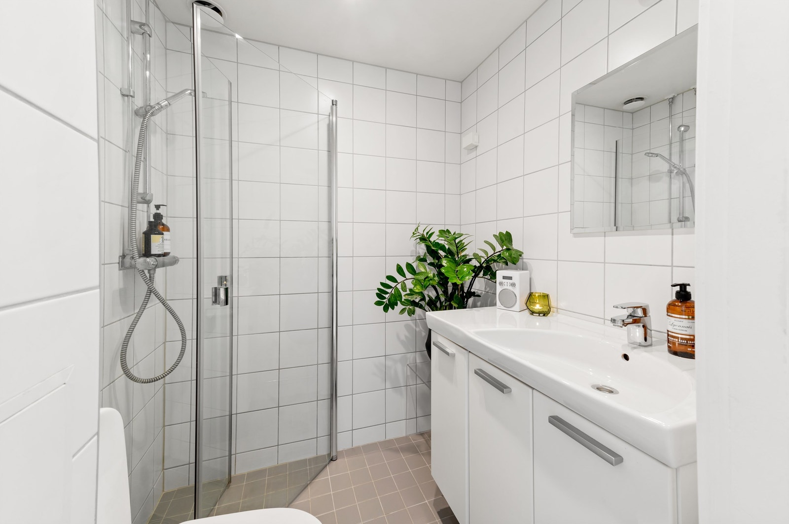 Badet er pent flislagt på gulv og vegger med varme i gulvet. Baderomsinnredningen består av vegghengt servantskap med nedfelt servant. Galleribilde