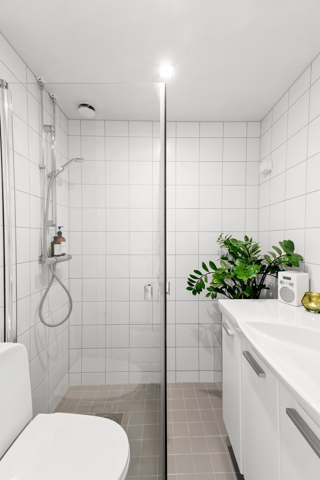 Videre har badet dusjhjørne med svingbare dører og gulvstående toalett. Det er opplegg for vaskemaskin. Galleribilde