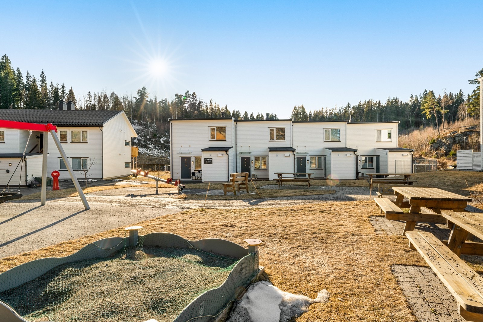 Flere benker og bord ved lekeplassen hvor man kan hygge seg med naboene Galleribilde