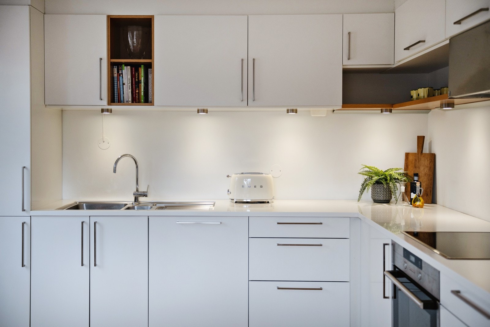 Kjøkkeninnredning med glatte fronter og corian benkeplater Galleribilde