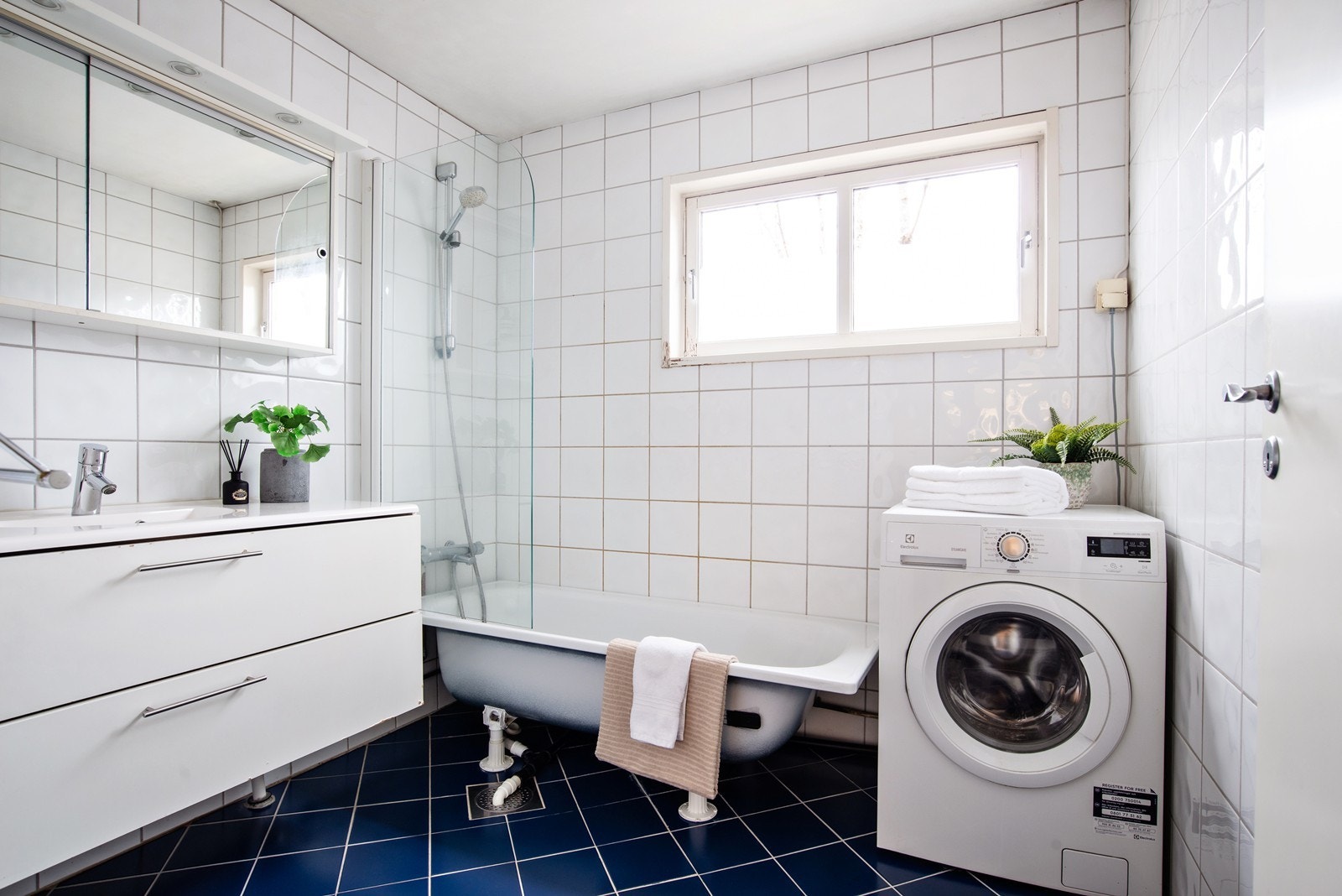 Flislagt bad med varmekabler i gulv og opplegg for vaskemaskin Galleribilde