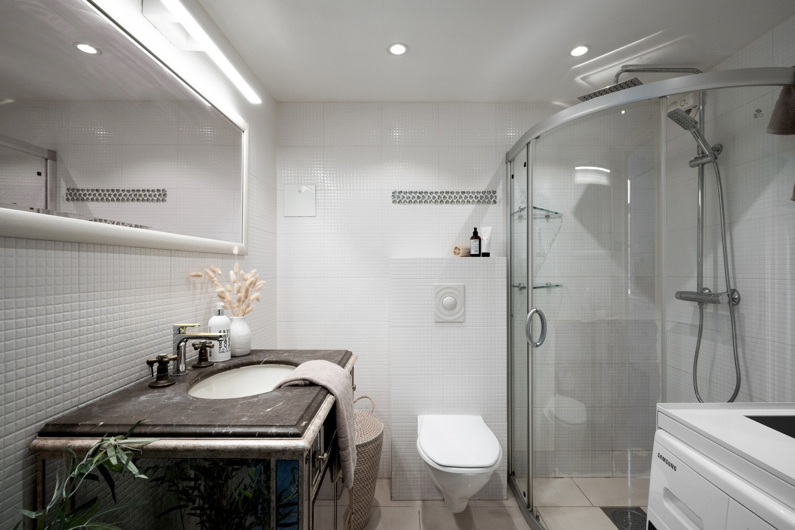 Det er romslig med plass til dusjhjørne, vegghengt toalett, seksjon med nedfelt servant og opplegg for vaskemaskin. Galleribilde