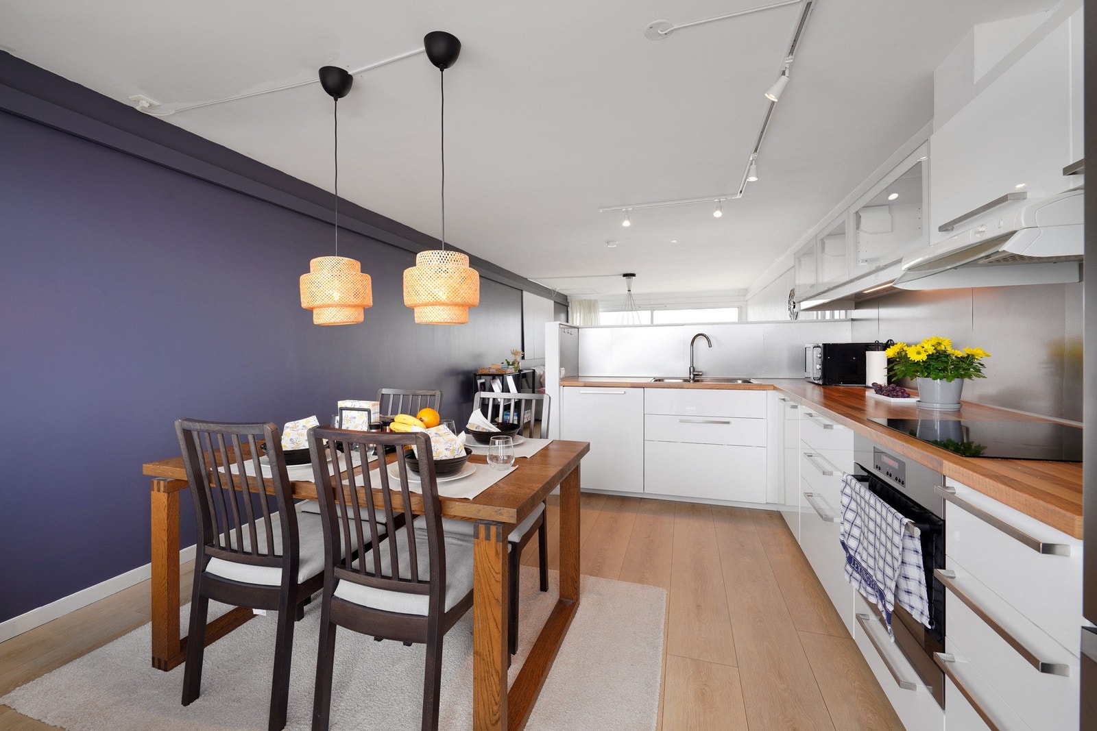 Pen åpen kjøkkenløsning med spisestue. Integrerte hvitevarer som stekeovn, platetopp og oppvaskmaskin. Galleribilde