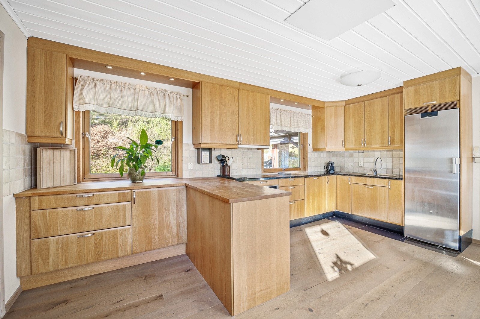 Kjøkken med integrerte hvitevarer og mye skap- og benkeplass. Galleribilde