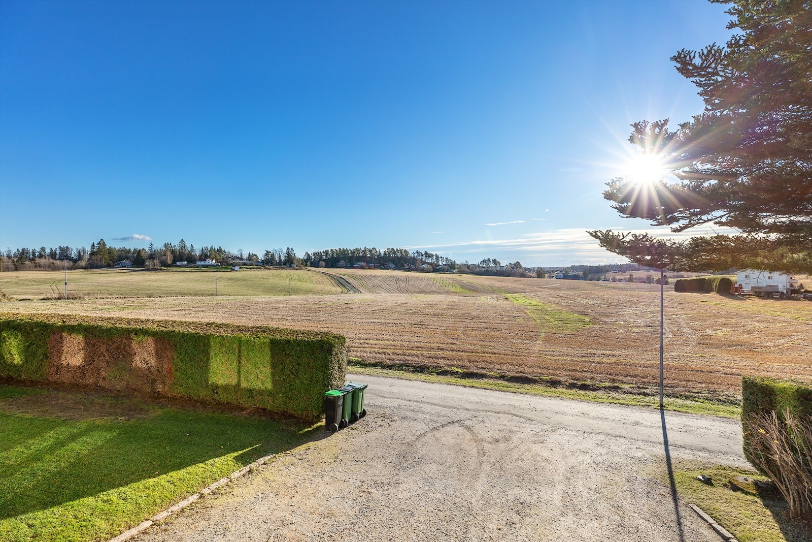 Gruset innkjøring og gårdsplass, med mye biloppstillingsplasser Galleribilde