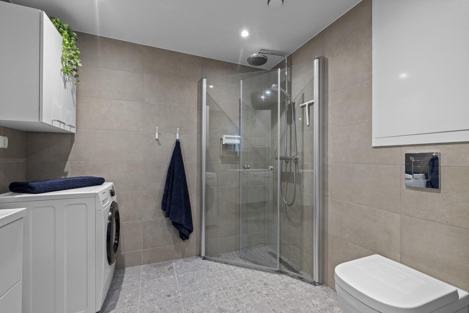 Innbydende og meget romslig bad med delikat flisvalg på gulv og vegg, vannbåren varme i gulv samt downlights i nedsenket himling Galleribilde