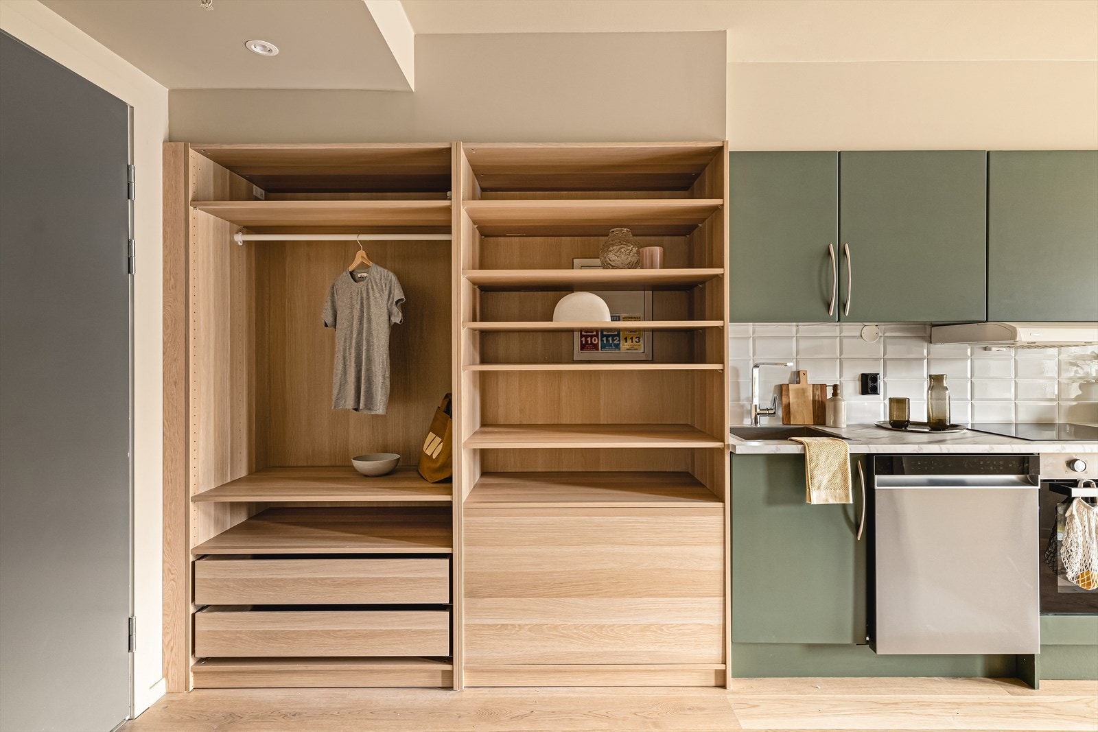 Praktisk og plassbesparende løsning med integrert garderobeskap i naturlig treverk. Galleribilde