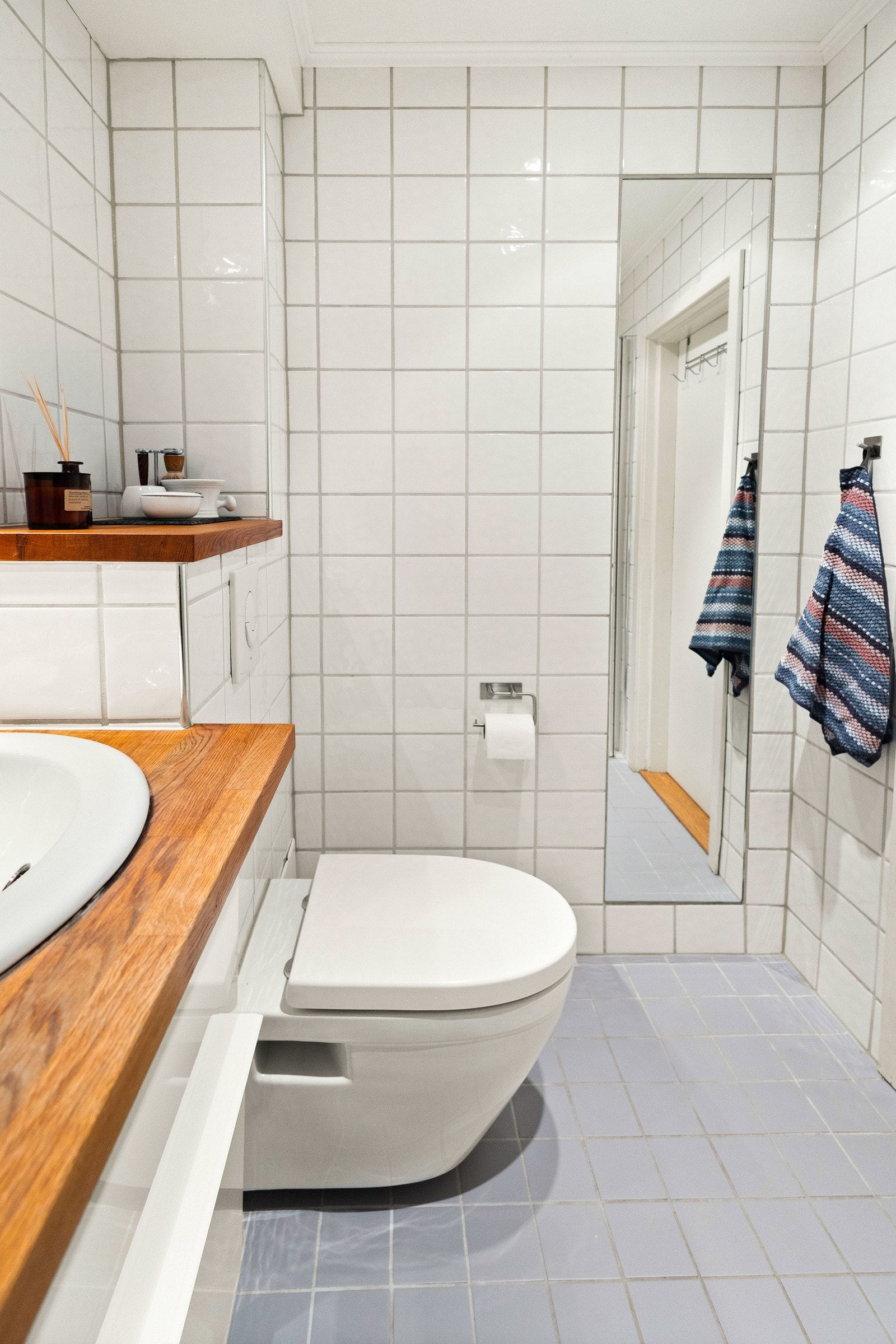 Baderomsinnredningen har hvite, glatte fronter og består av en skuffeseksjon under en heltrebenkeplate med nedfelt servant. Galleribilde