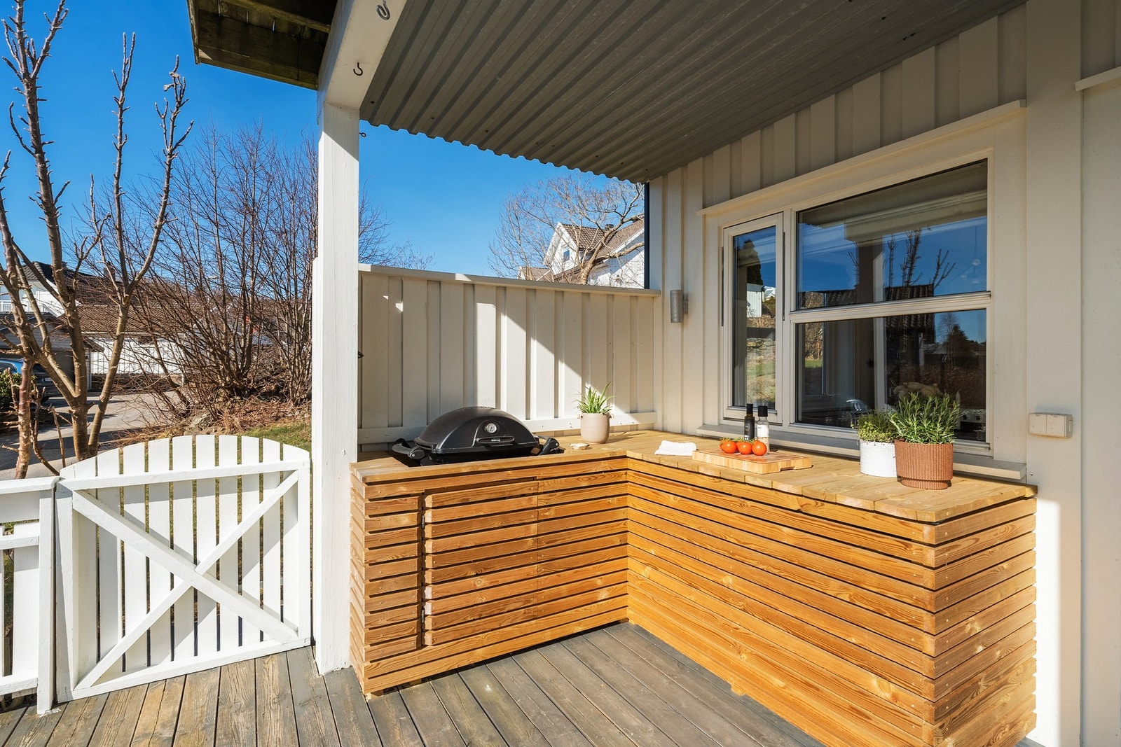 - Det er bygget et flott utekjøkken med egen plass til grillen | Det er også inngang fra bakkeplan gjennom porten - Galleribilde