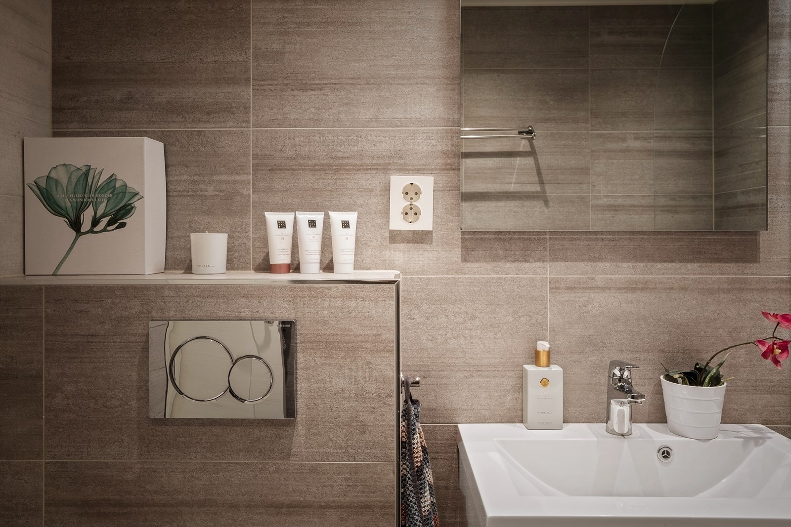 Badet har flislagte overflater og malte plater i taket. Det er varmekabler i gulvet. Det er ventilasjon via mekanisk avtrekk til, til luft under døren. Galleribilde