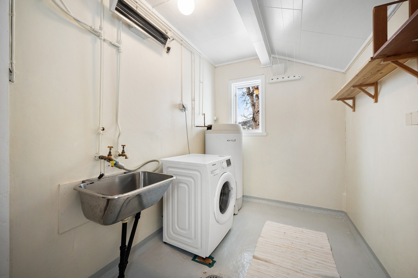 Vaskerom med opplegg for vaskemaskin og tørketrommel, samt utslagsvask og varmtvannsbereder Galleribilde