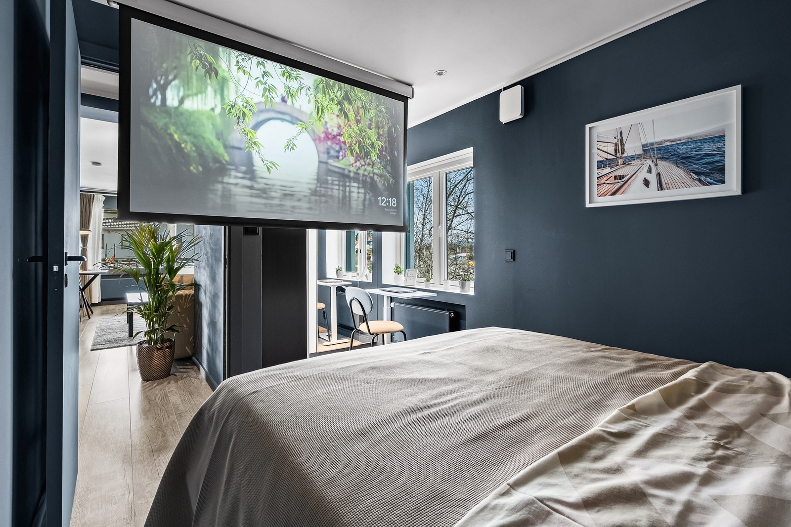 Soverommet er utstyrt med opplegg for hjemmekino med elektrisk lerret og projektor gjemt i skap over seng. Galleribilde