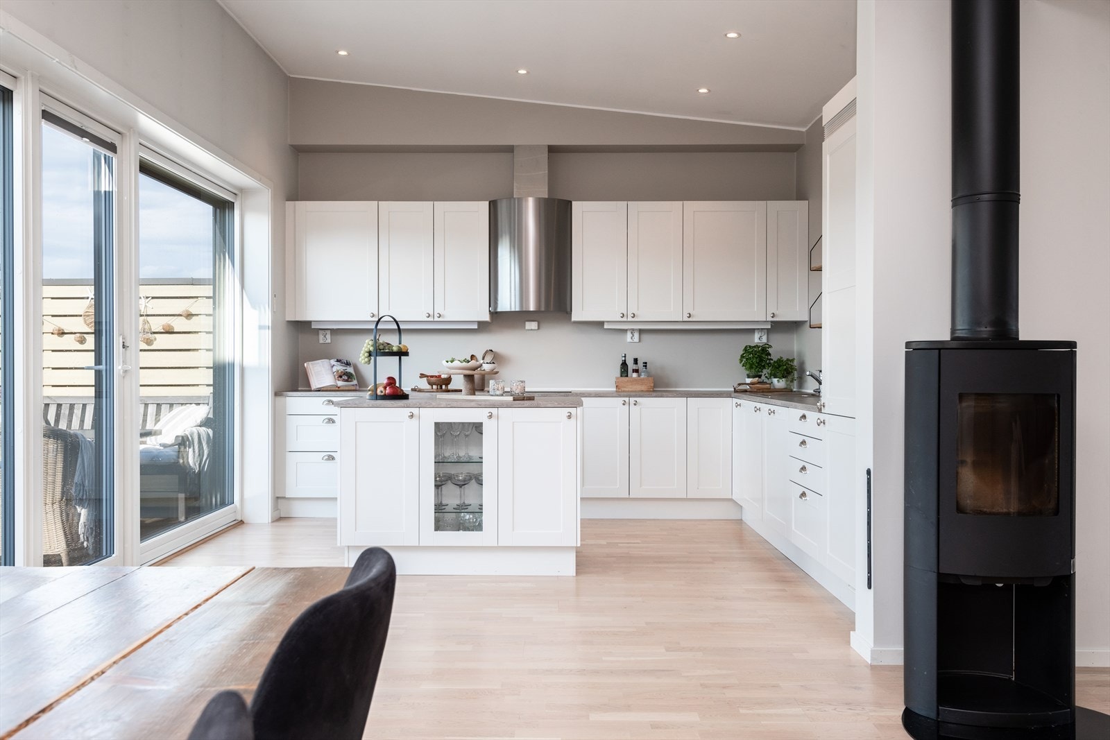 Elegant kjøkken fra Sigdal med kjøkkenøy og moderne hvitevarer. Kjøkkenet har utgang til terrassen, perfekt for å kombinere matlaging med utekos. Galleribilde