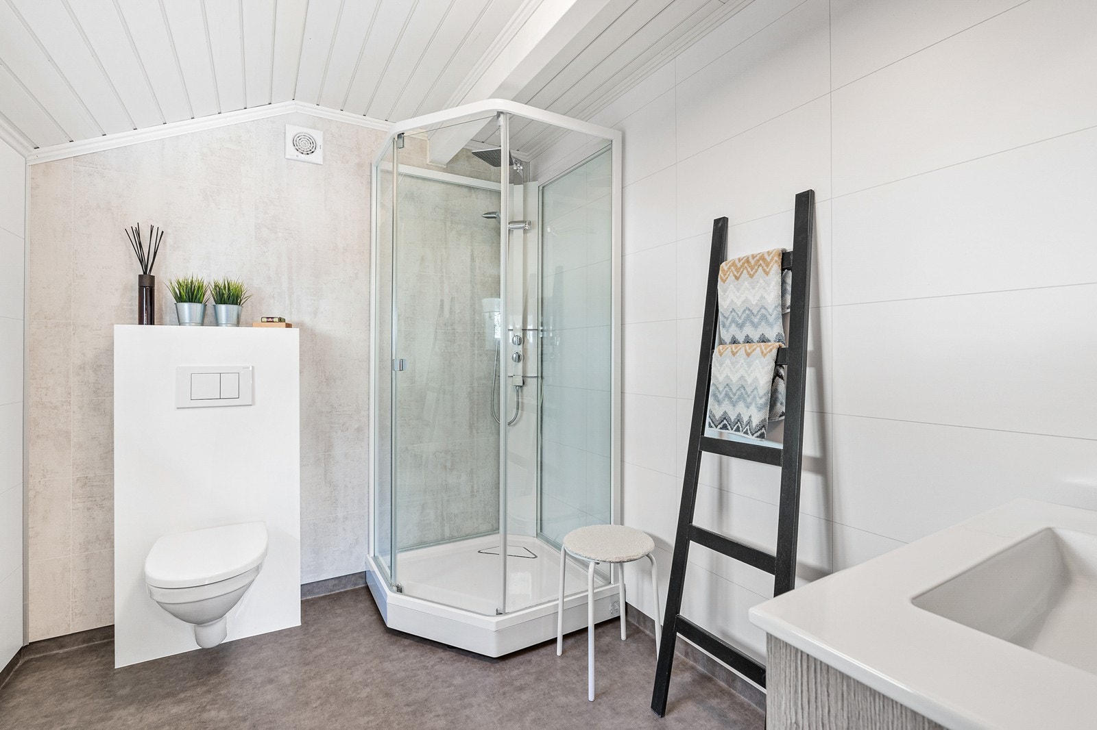 Etasjens bad har gulvbelegg med varmekabler, baderomsplater på vegger og panel i taket. Galleribilde