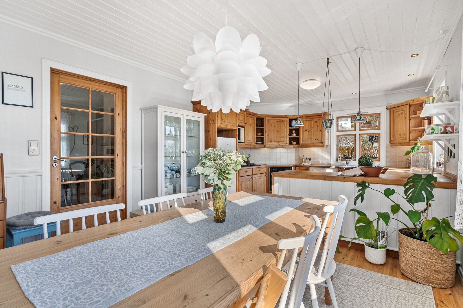 Kjøkkenet har profilerte fronter, fliser på veggen over benkeplaten i tre. Galleribilde