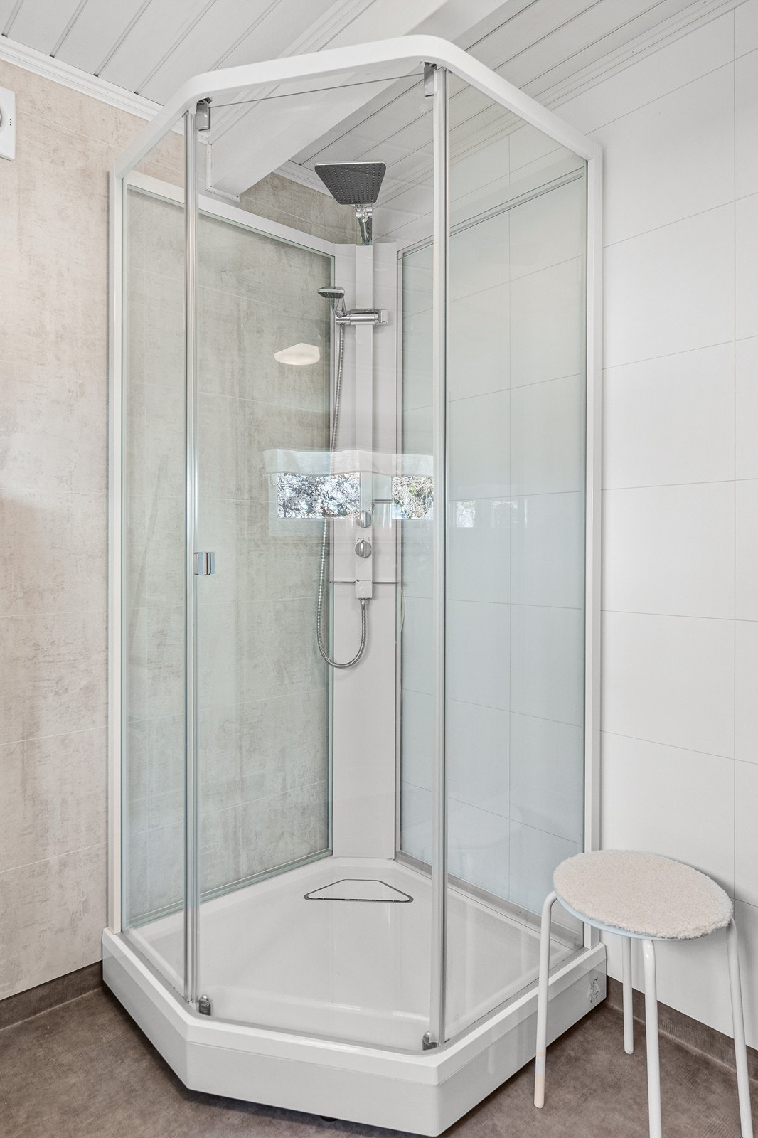 Badet er innredet med dusjkabinett, vegghengt toalett og baderomsinnredning med vask. Galleribilde