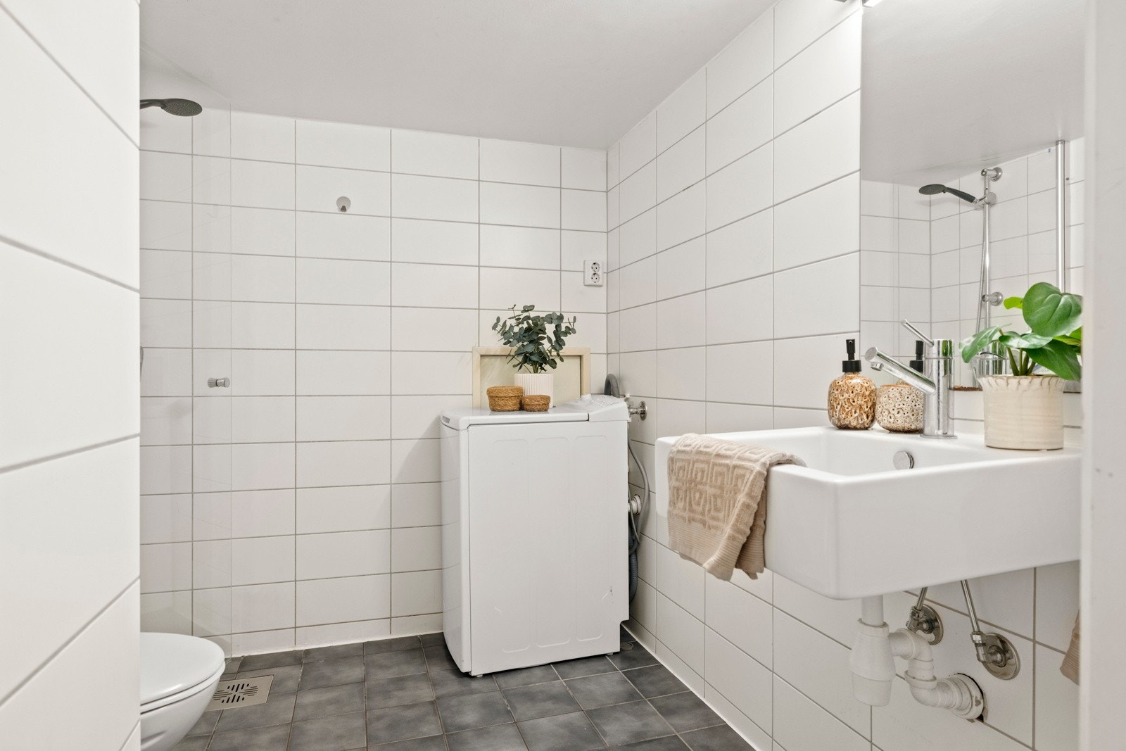 Moderne og romslig baderom fra med dusjhjørne, vegghengt WC og opplegg for vaskemaskin. Galleribilde