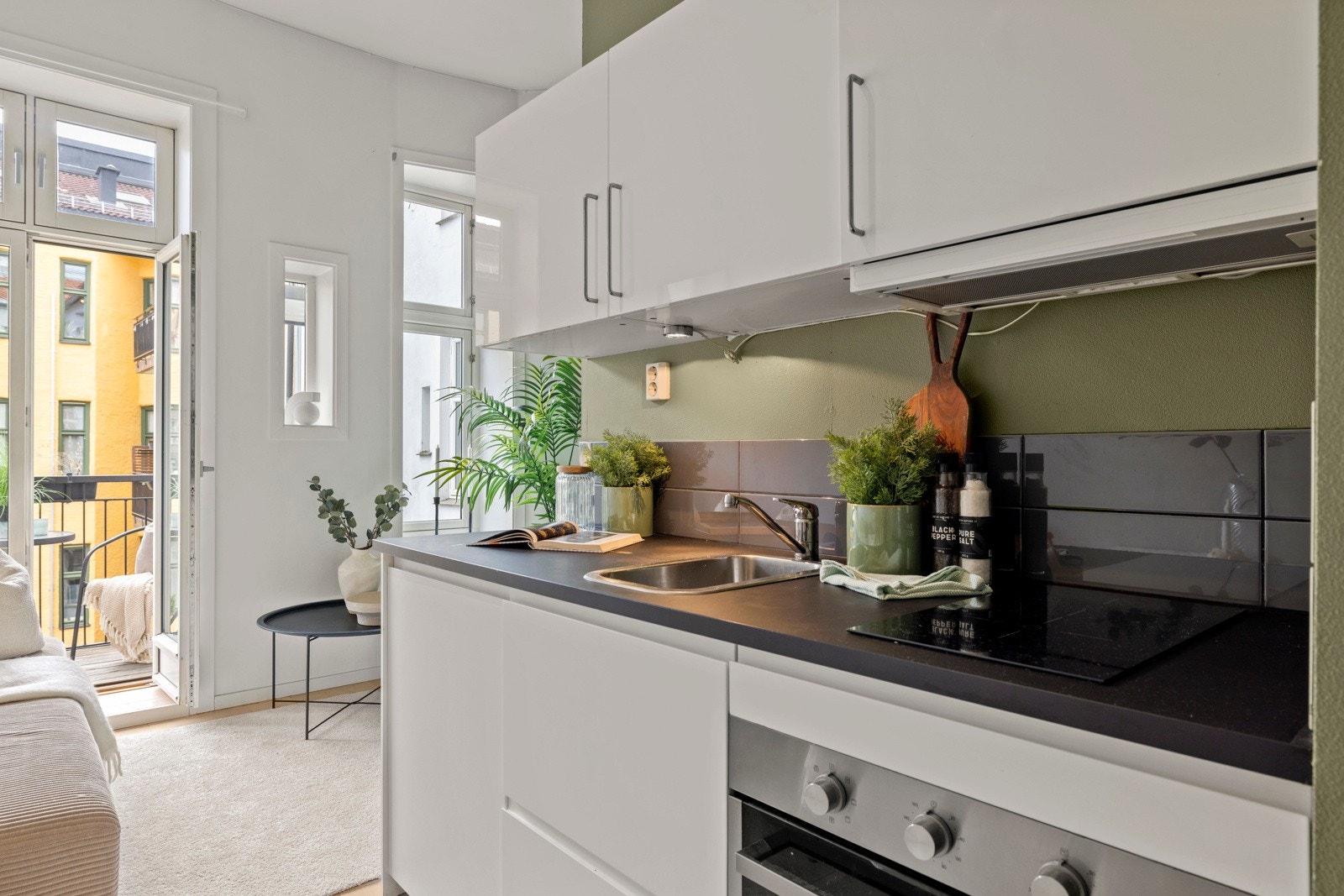 Kjøkkeninnredningen fra 2019 har hvite glatte fronter, laminat benkeplate med nedfelt kum i rustfritt stål. Galleribilde