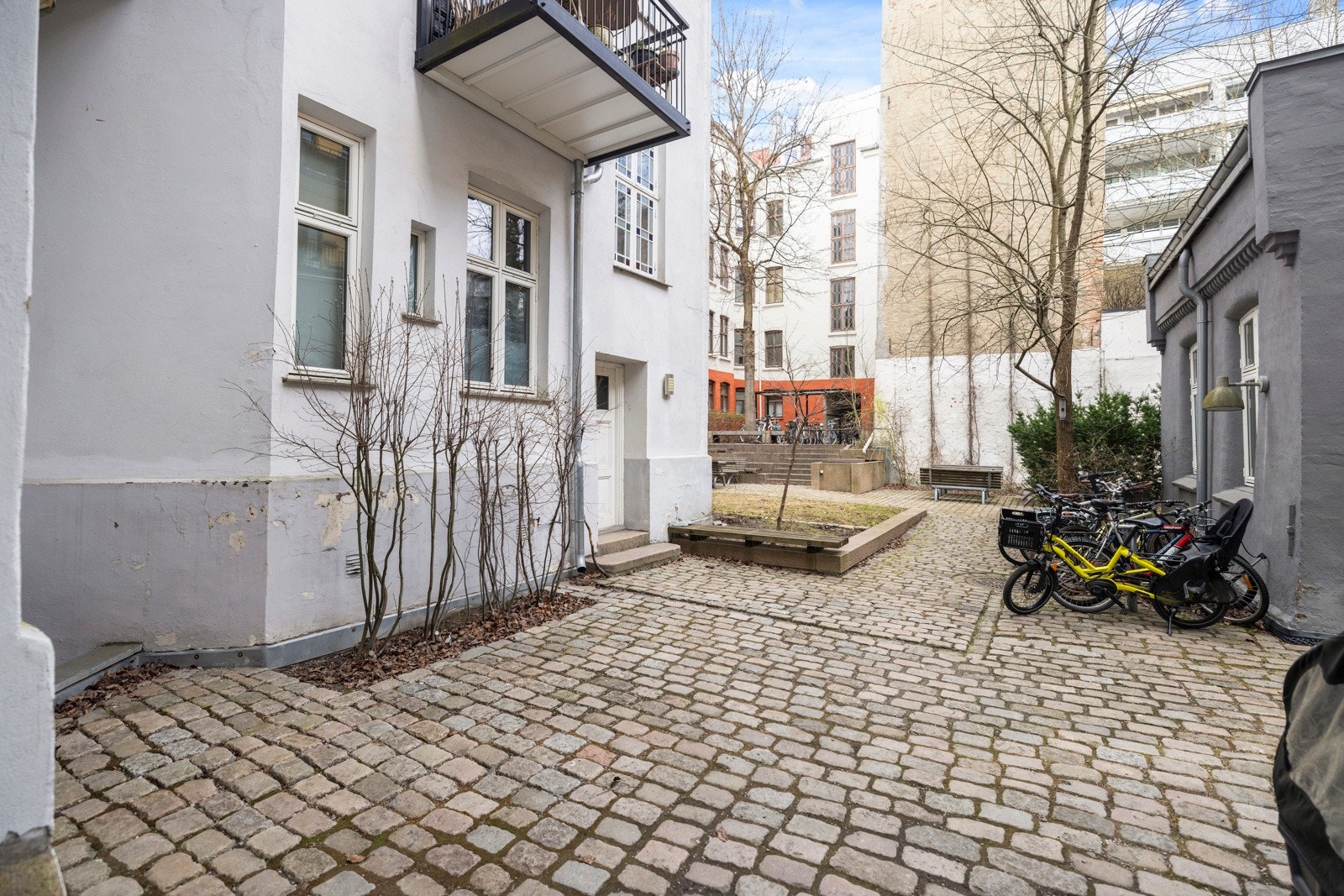 Bakgården er pent opparbeidet med flere sittegrupper, beplantning og felles grill. Galleribilde