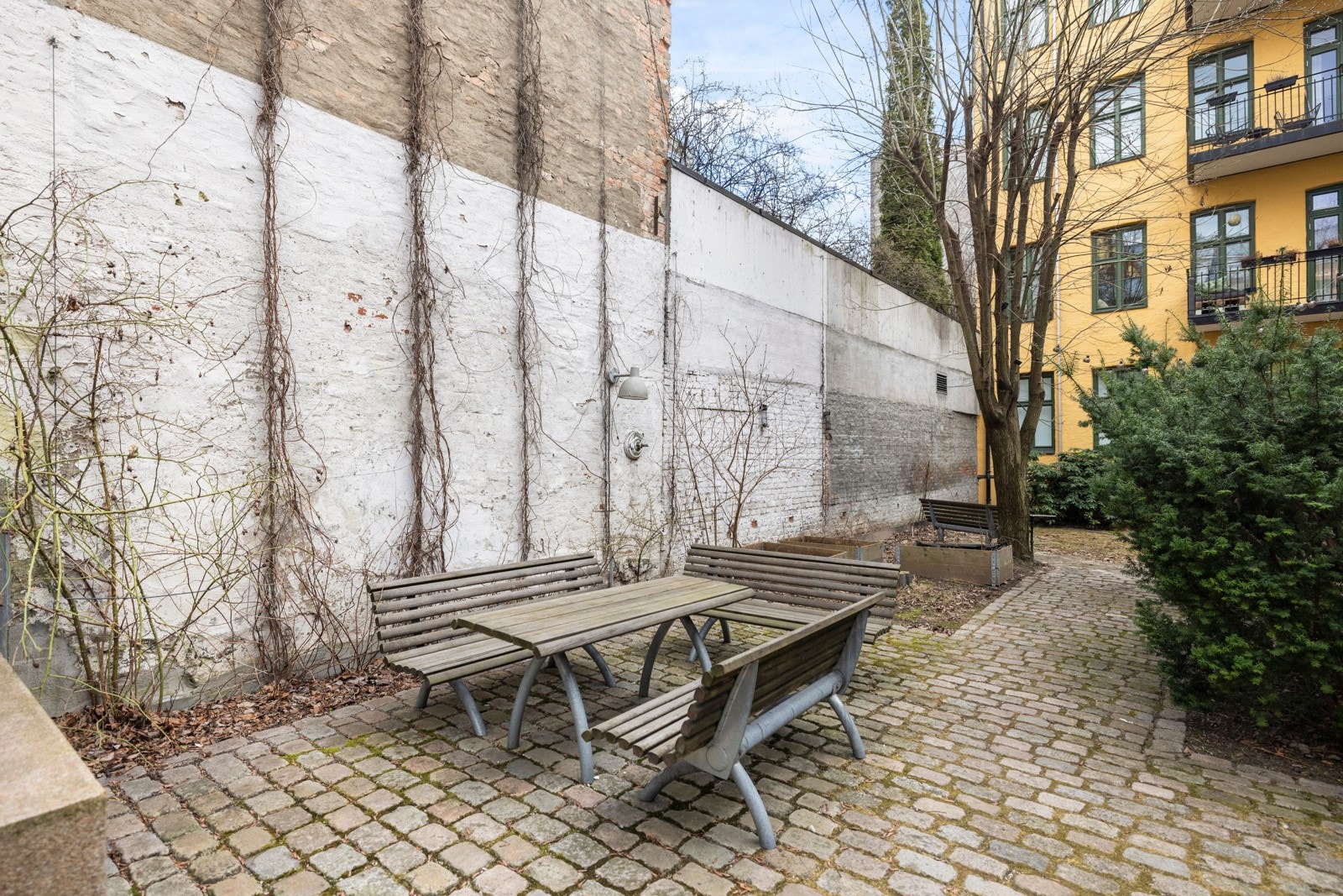 Bakgården er pent opparbeidet med flere sittegrupper, beplantning og felles grill. Galleribilde
