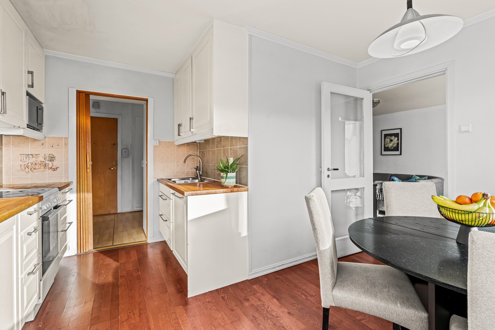 Innredningen fra 2012 har hvite, profilerte fronter, takhøye skap og gyllen, solid heltrebenkeplate med nedfelt kum i stål Galleribilde