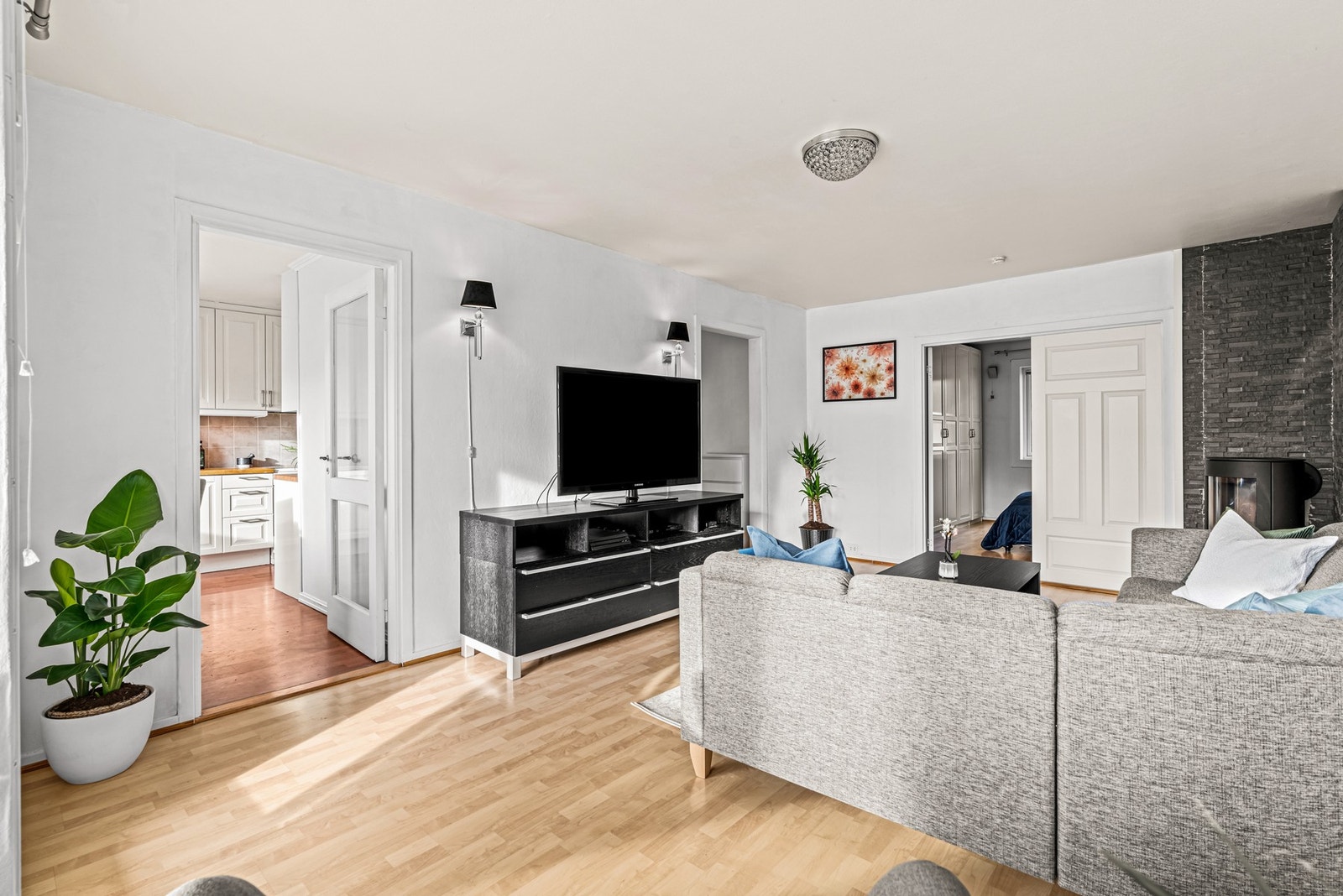 Leiligheten har en luftig og innbydende stue med hvitmalte overflater Galleribilde