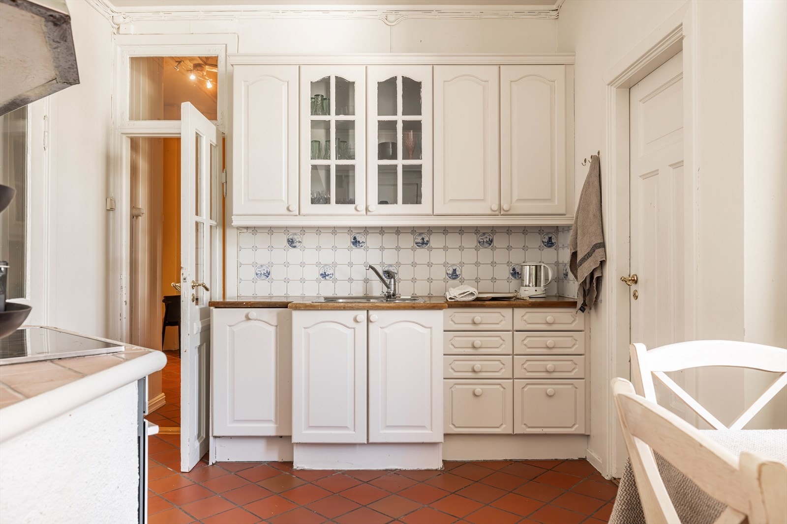 Et separat og sjarmerende kjøkken med fliser på gulvet og mellom over- og underskap. Fra kjøkkenet er det adkomst til soverom nr. 3. Her er det mulighet for å plassere kjøle-fryseskap, vaskemaskin, tørkestativ etc. om man ikke har behov for 3 soverom. Galleribilde