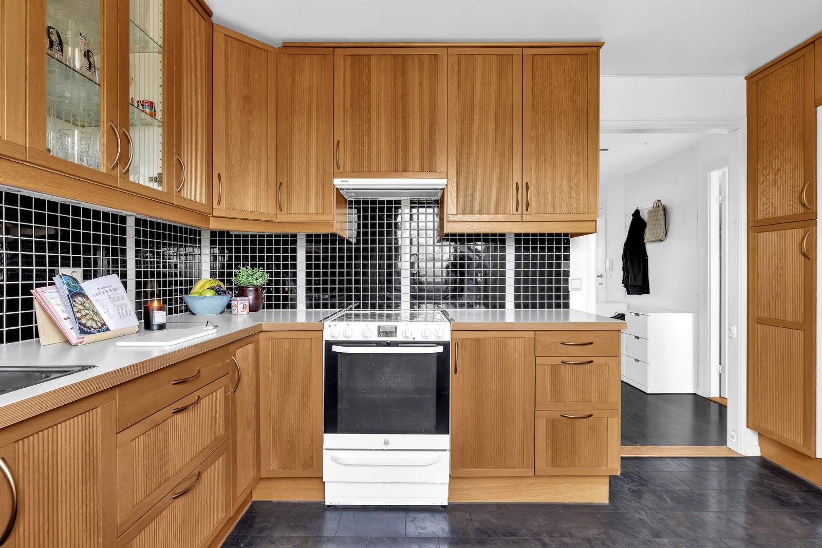 Kjøkkenet har frittstående hvitevarer som stekeovn med koketopp, kombiskap med kjøle- og frysedel, oppvaskmaskin og ventilator. Galleribilde