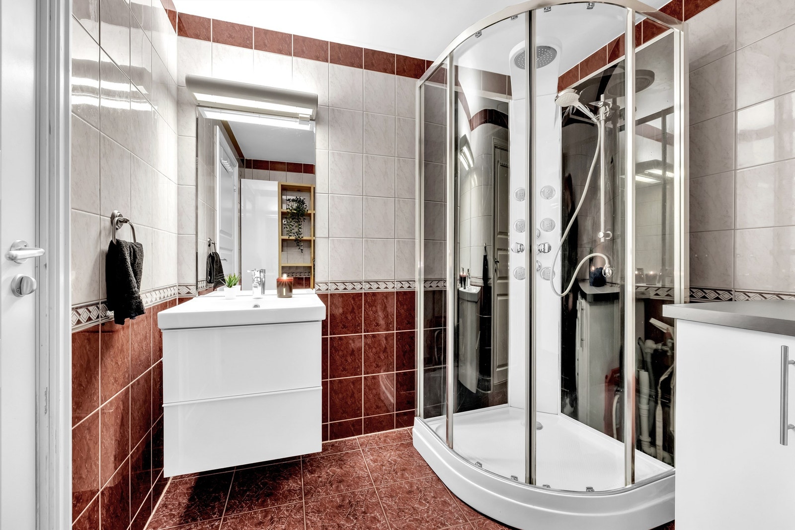 Badet er ellers utstyrt med en vegghengt servantinnredning med servant og dusjkabinett med skyvedører, Galleribilde