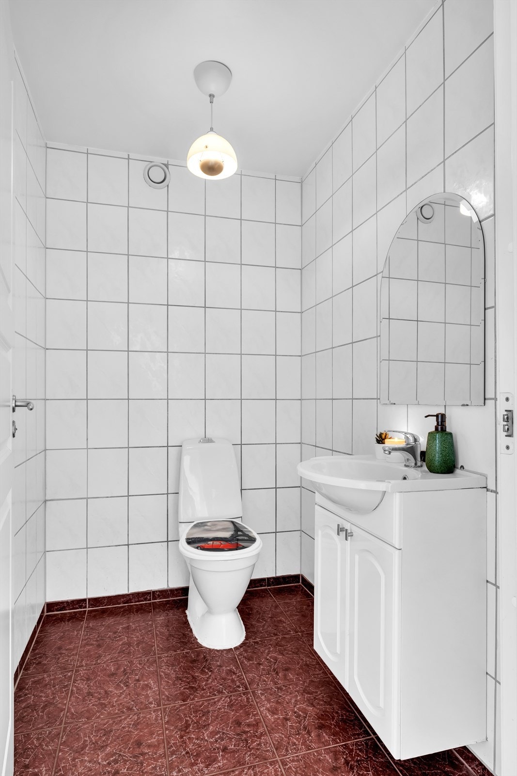 Separat toalettrom med gulvstående toalett og vegghengt servantskap. Galleribilde