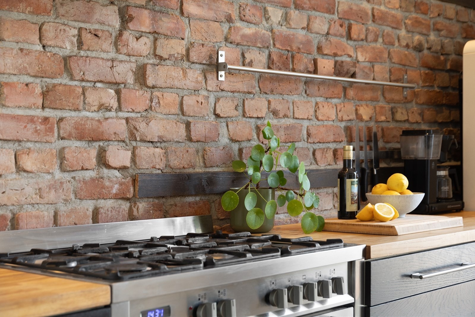 Integrerte hvitevarer bestående av gass/ el-komfyr, oppvaskmaskin og vaskemaskin. Legg merke til den originale teglsteinsveggen som setter sitt preg på rommet. Galleribilde