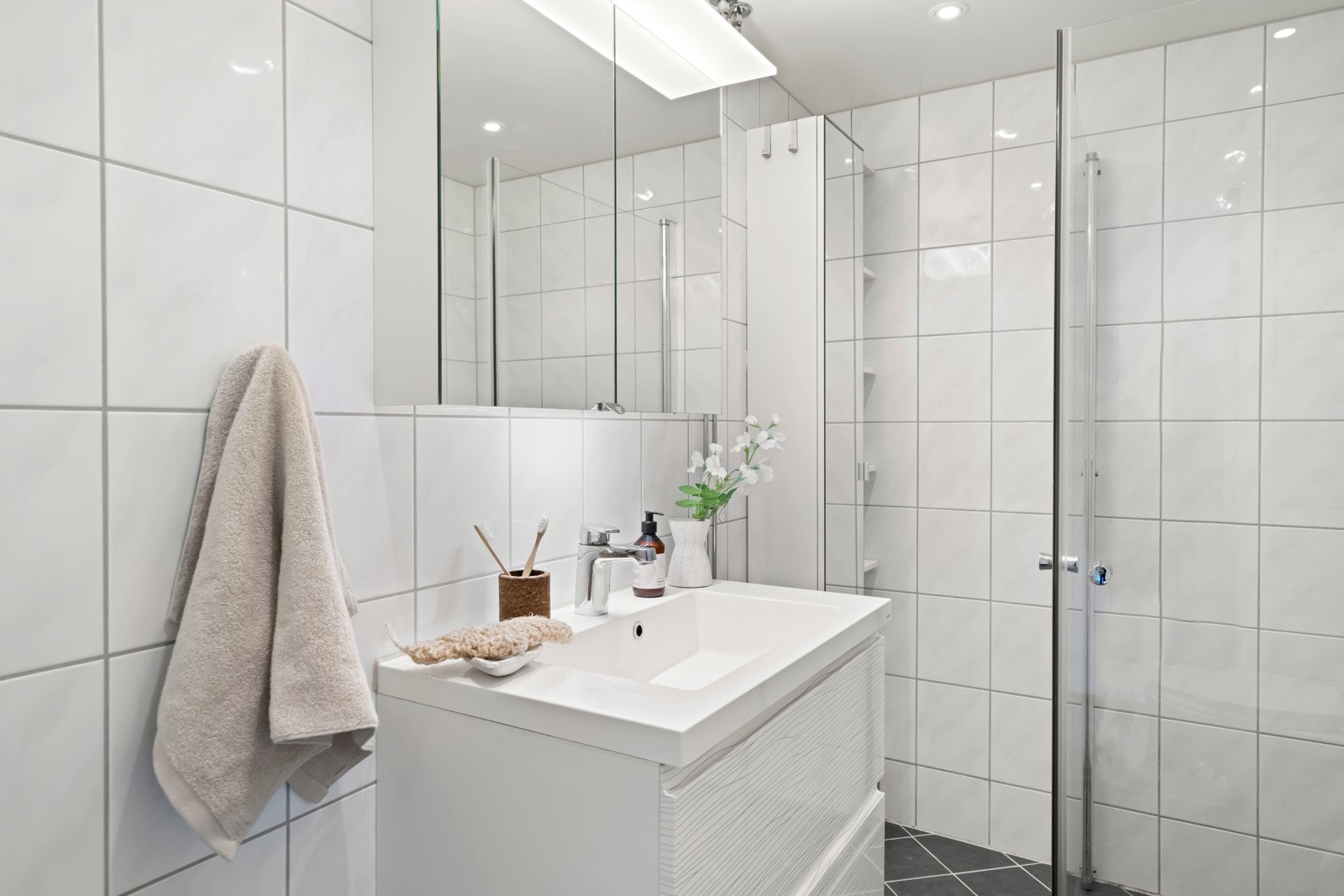Moderne flis- og materialvalg i hvitt med grå fliser på gulv. Galleribilde