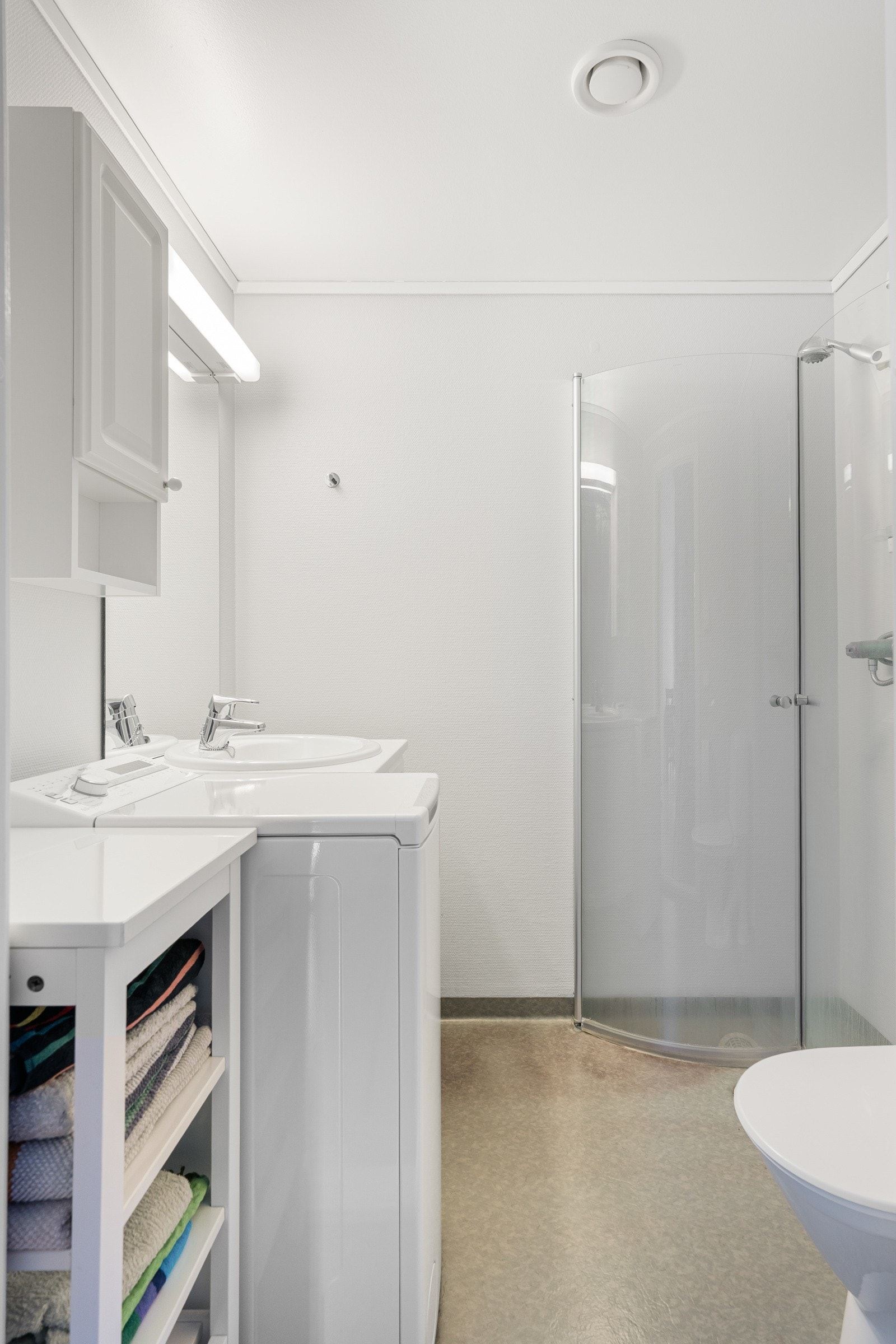 Baderommet er innredet med toalett, dusjhjørne og en praktisk baderomsinnredning. Galleribilde