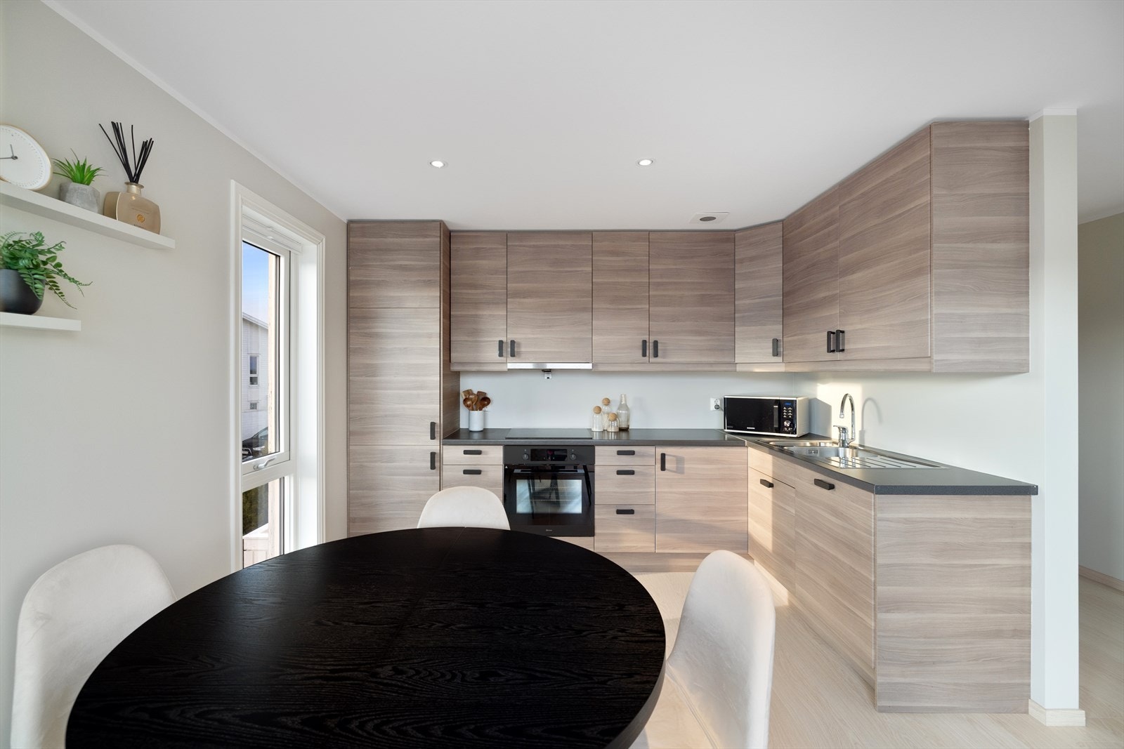 Kjøkkenet har flott innredning med slette fronter, benkeplate av laminat, nedfelt oppvaskkum og ventilator i overskap. Galleribilde