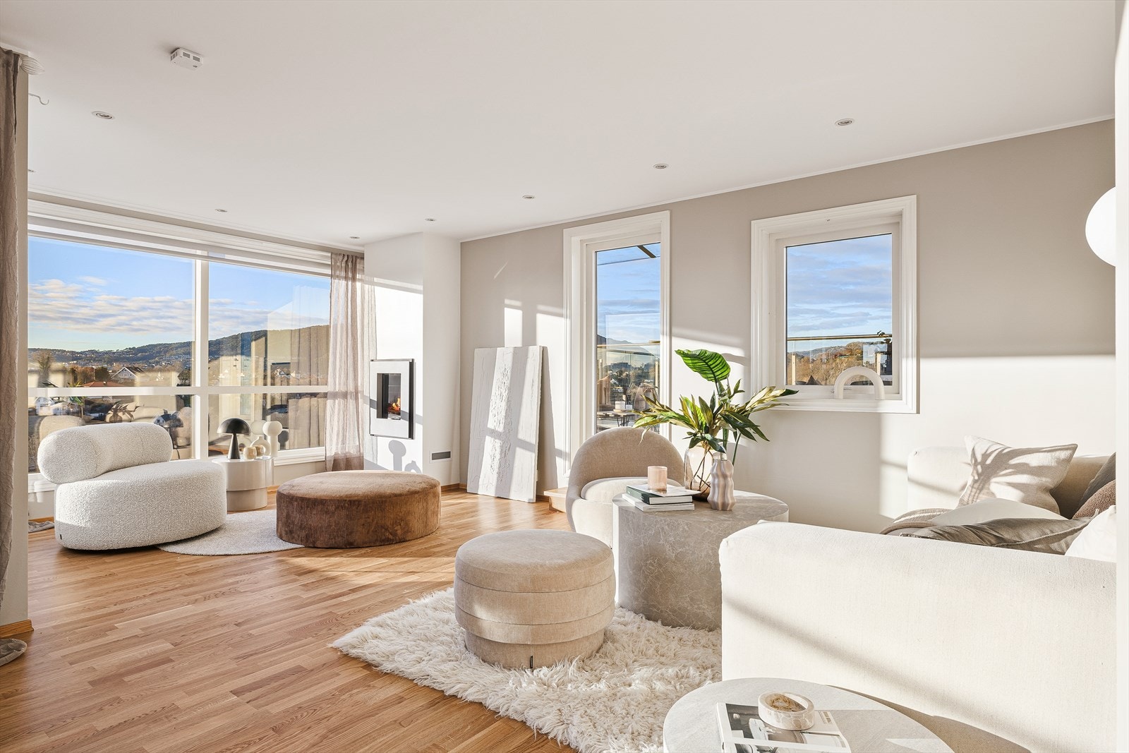 Lys og elegant stue med store vindusflater, downlights i taket og direkte overgang til en stor terrasse. Galleribilde