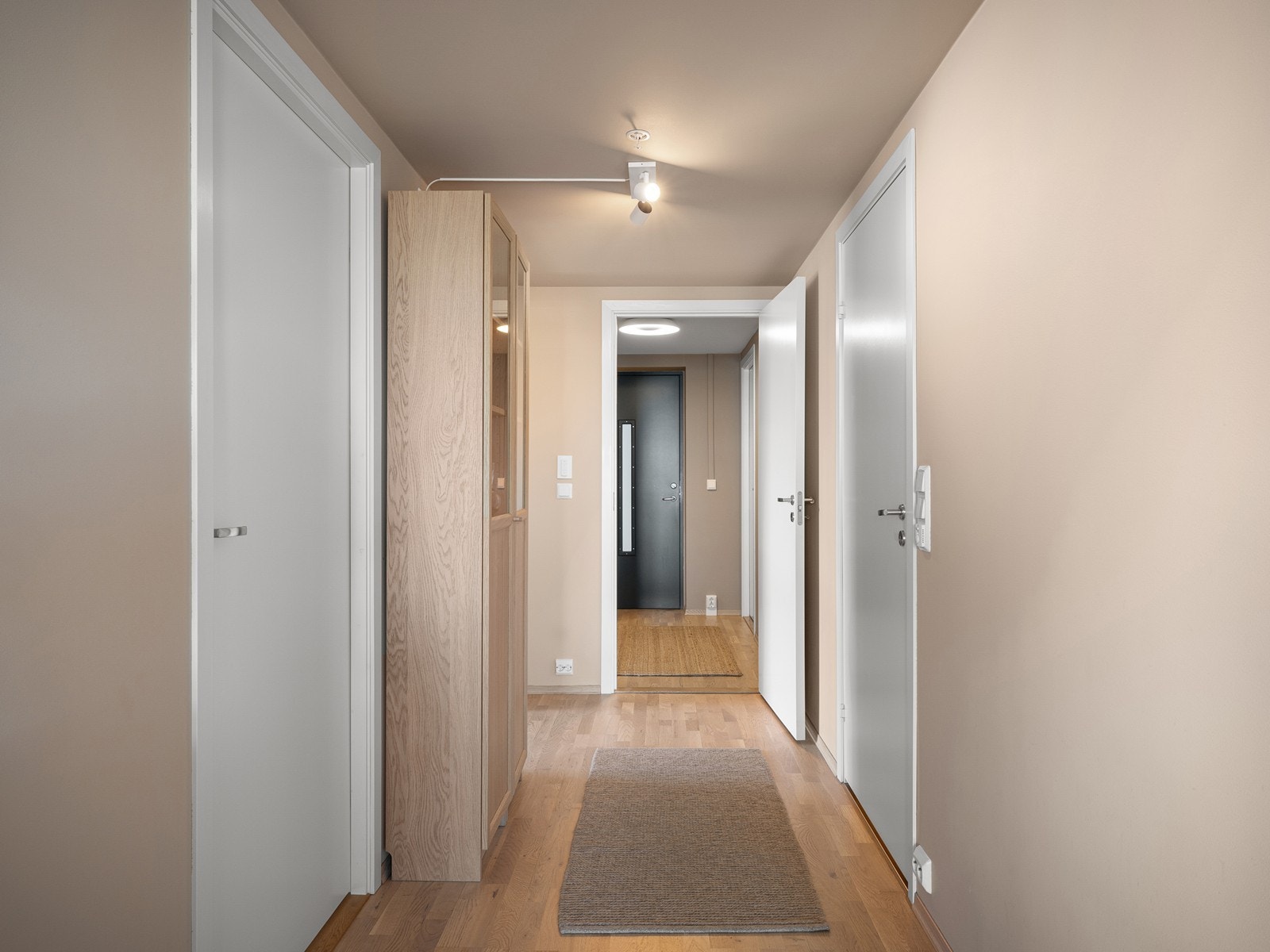 Entré/gang med parkett på gulv og innhukk for oppheng av klær. Galleribilde