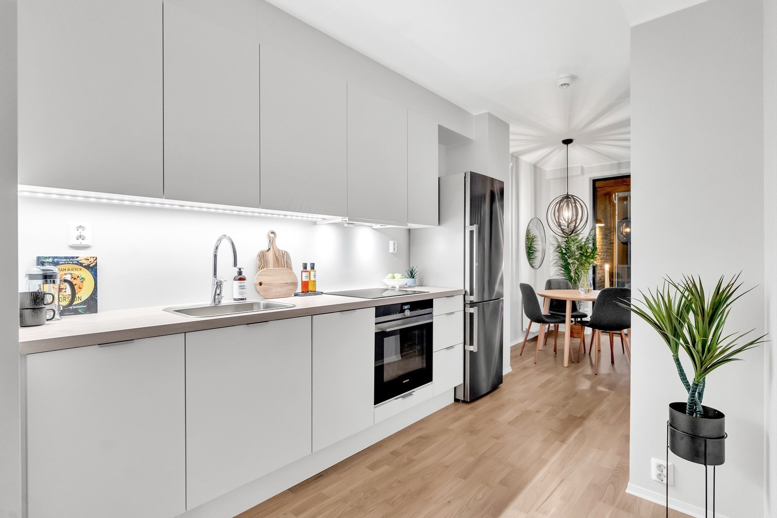 Stilren kjøkkeninnredning som kler resten av rommet godt. Galleribilde