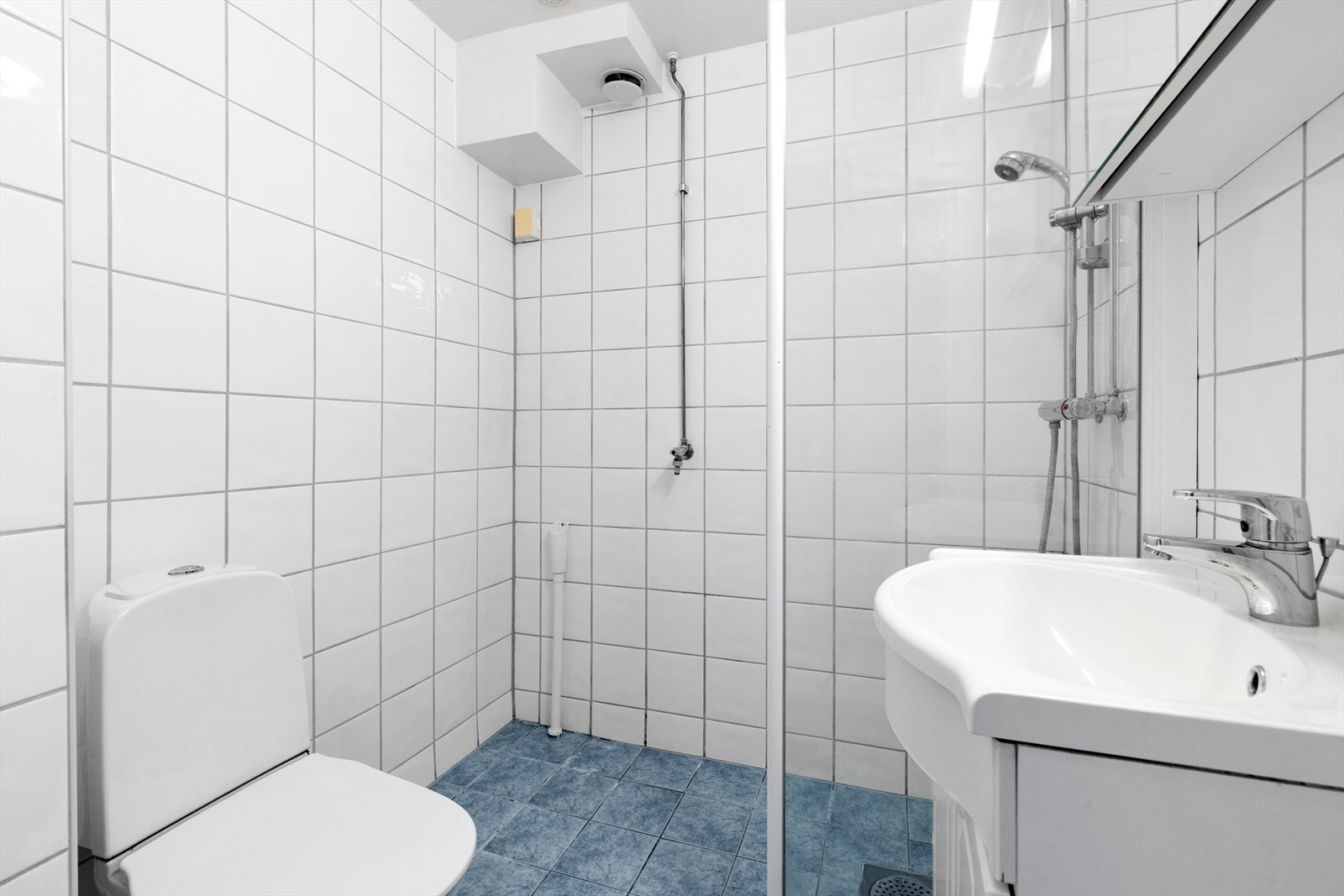 Baderomsinnredning med nedfelt servant på underskap og speilskap med belysning over. Galleribilde