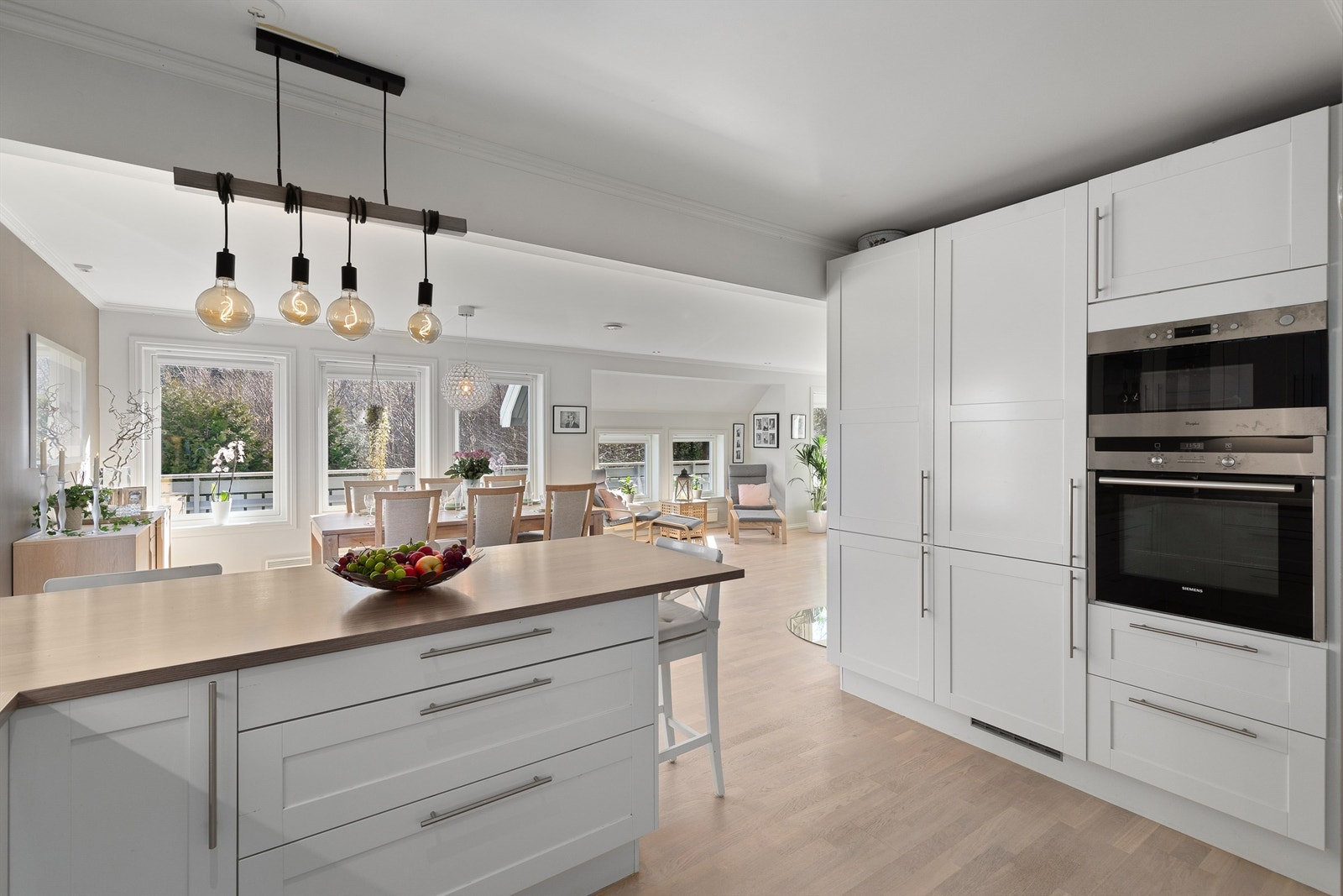 Lyst og pent kjøkken i åpen løsning mot spisestuen Galleribilde