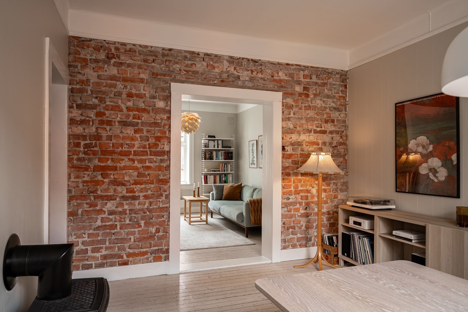 Den rustikke murveggen gir et særpreg til leiligheten Galleribilde