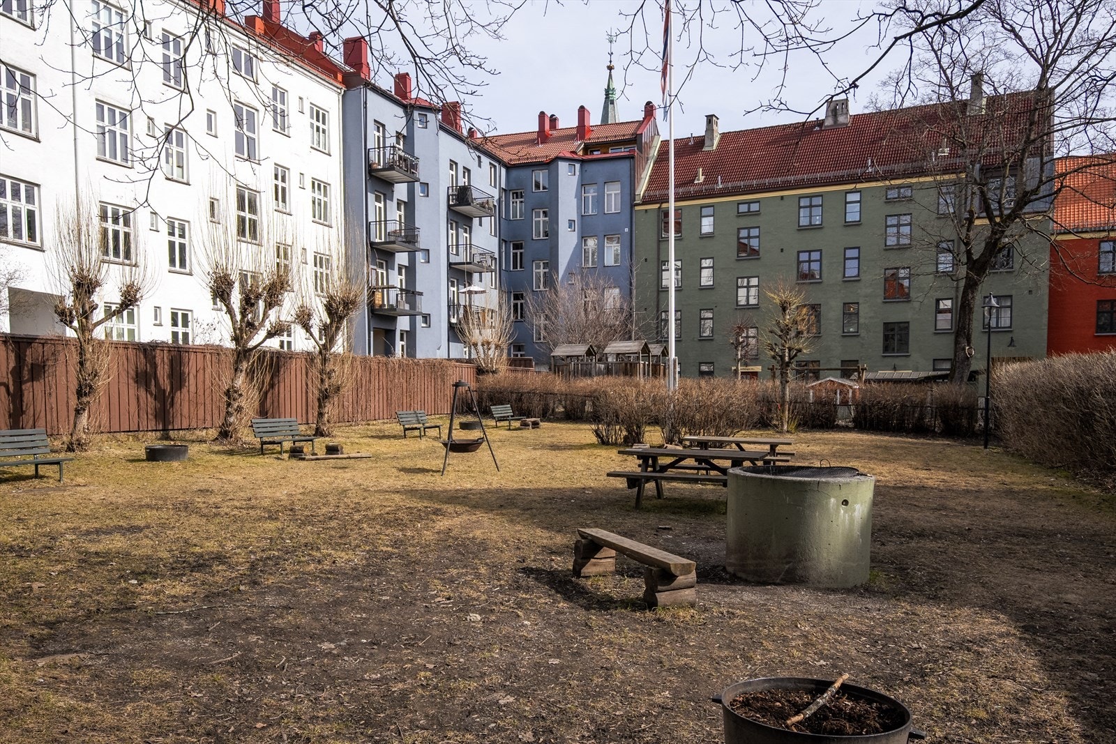 Hyggelig bakgård med flere sittegrupper, plen og beplantning Galleribilde