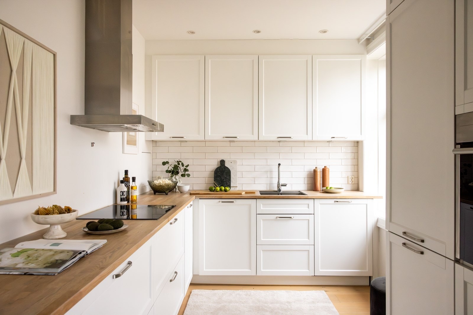 - Moderne kjøkkeninnredning med profilerte fronter, heltre benkeplate med nedfelt vaskekum, samt fliser og belysning over benkeplaten - Galleribilde