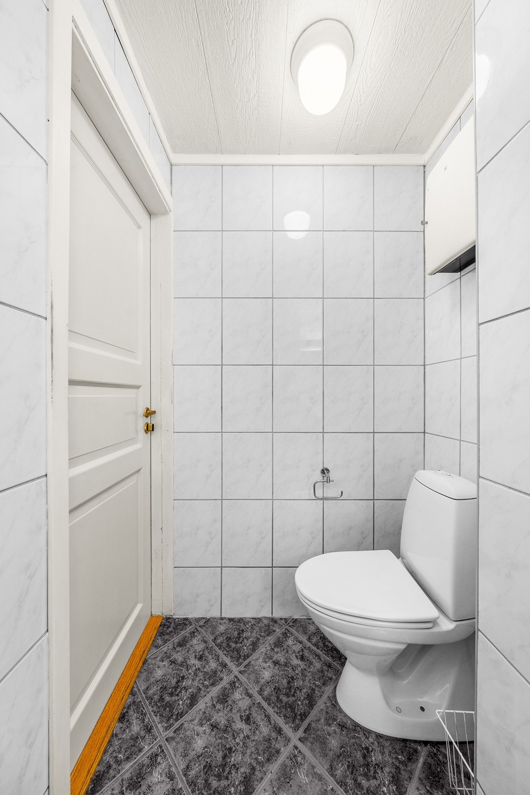 Badet oppe er innredet med sorte gulvfliser og lyse veggfliser. Galleribilde