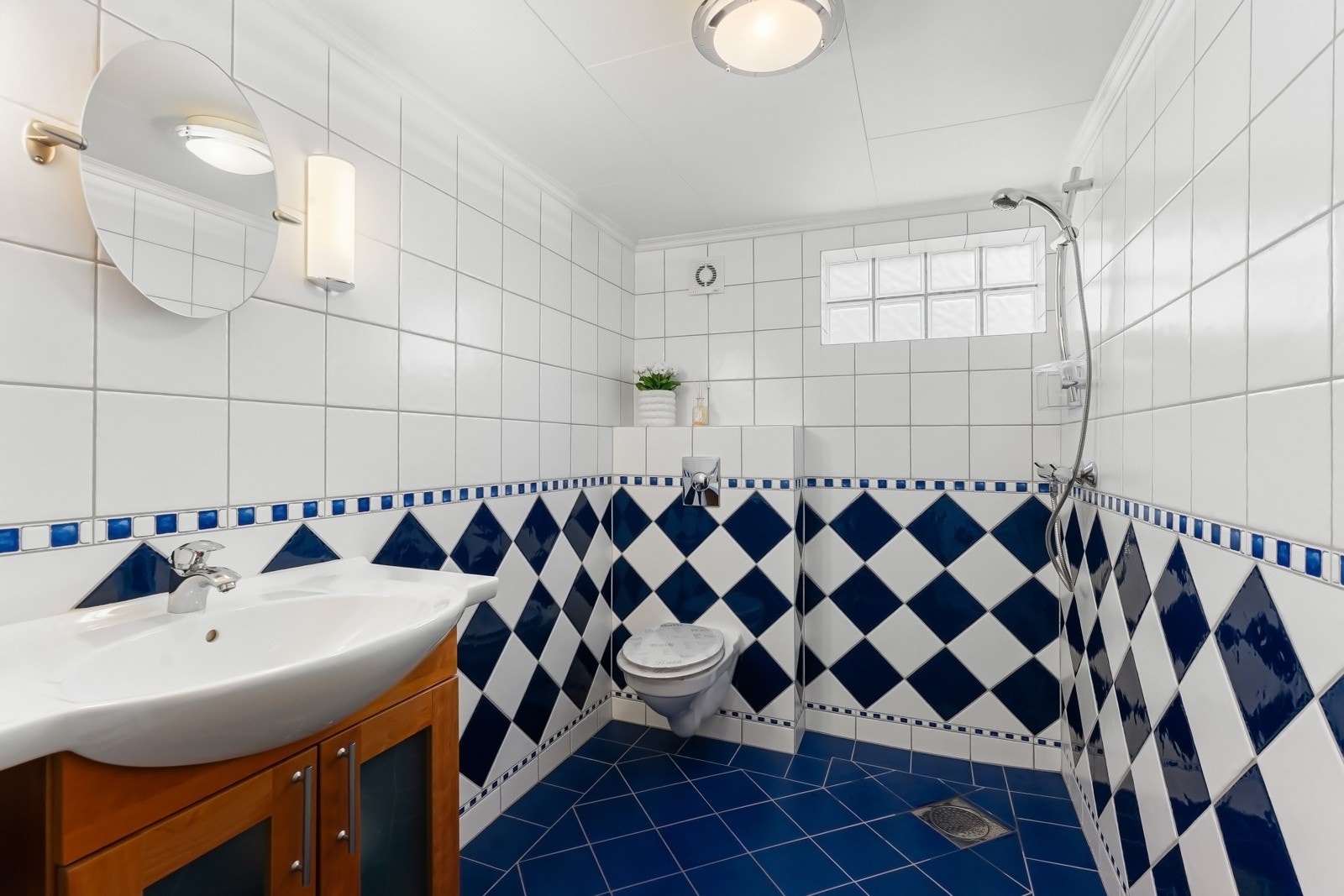 Badet i kjelleren er fra 2005 og har flislagte gulv og vegger. Gulvet har varmekabler, og rommet er innredet med vegghengt toalett, servant og dusjnisje Galleribilde