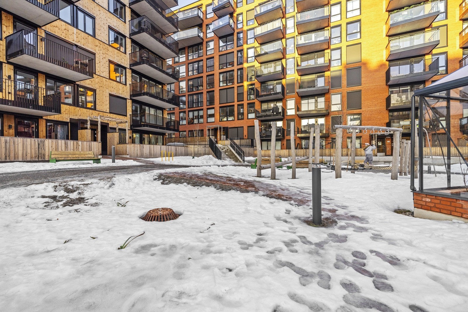 Felles og svært hyggelig bakgård som er pent opparbeidet med benker, lekeapparater for barn og drivhus gjør gårdtunet til trivelige oppholdsrom Galleribilde