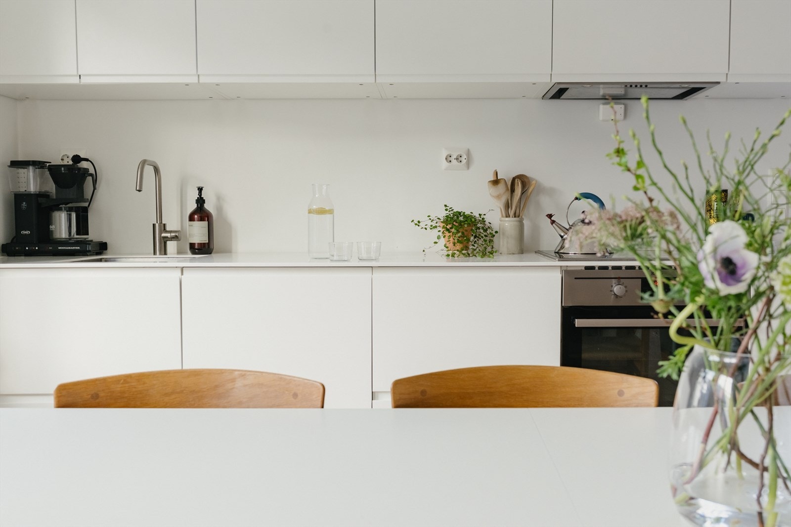 Kjøkkenet er utstyrt med integrerte hvitevarer som oppvaskmaskin, platetopp og stekeovn, samt et frittstående kjøleskap under trappen. Galleribilde