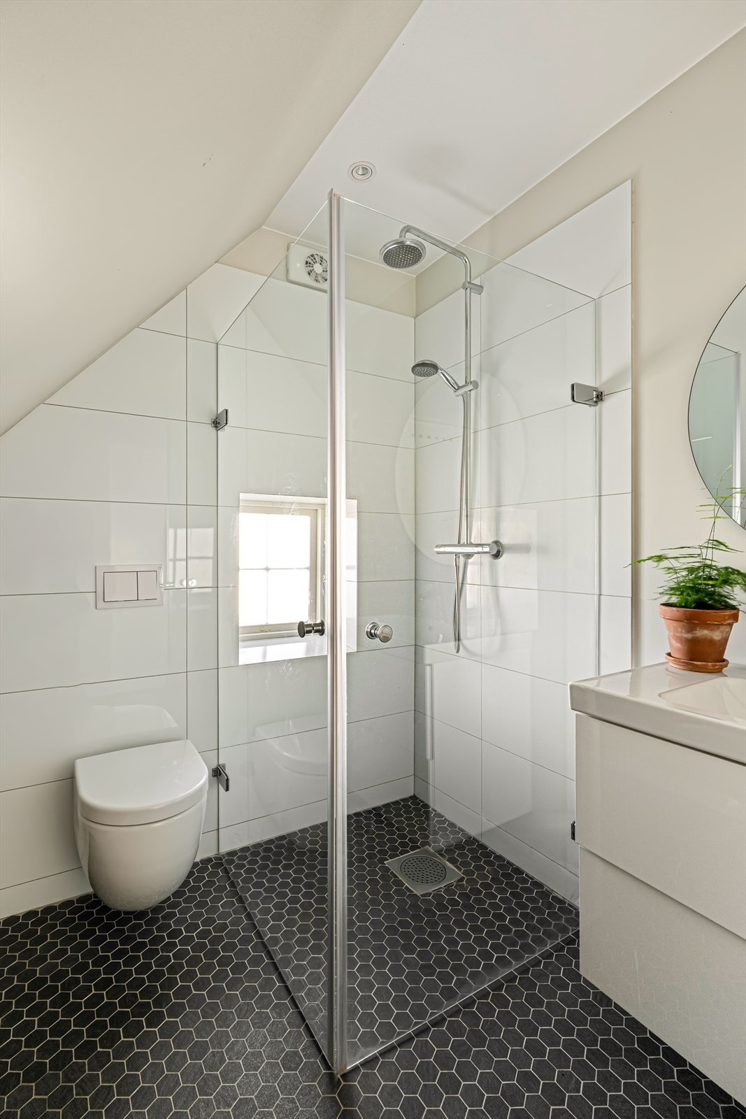 Det er innredet med vegghengt toalett, servant i baderomsmøbel og et praktisk dusjhjørne. Galleribilde