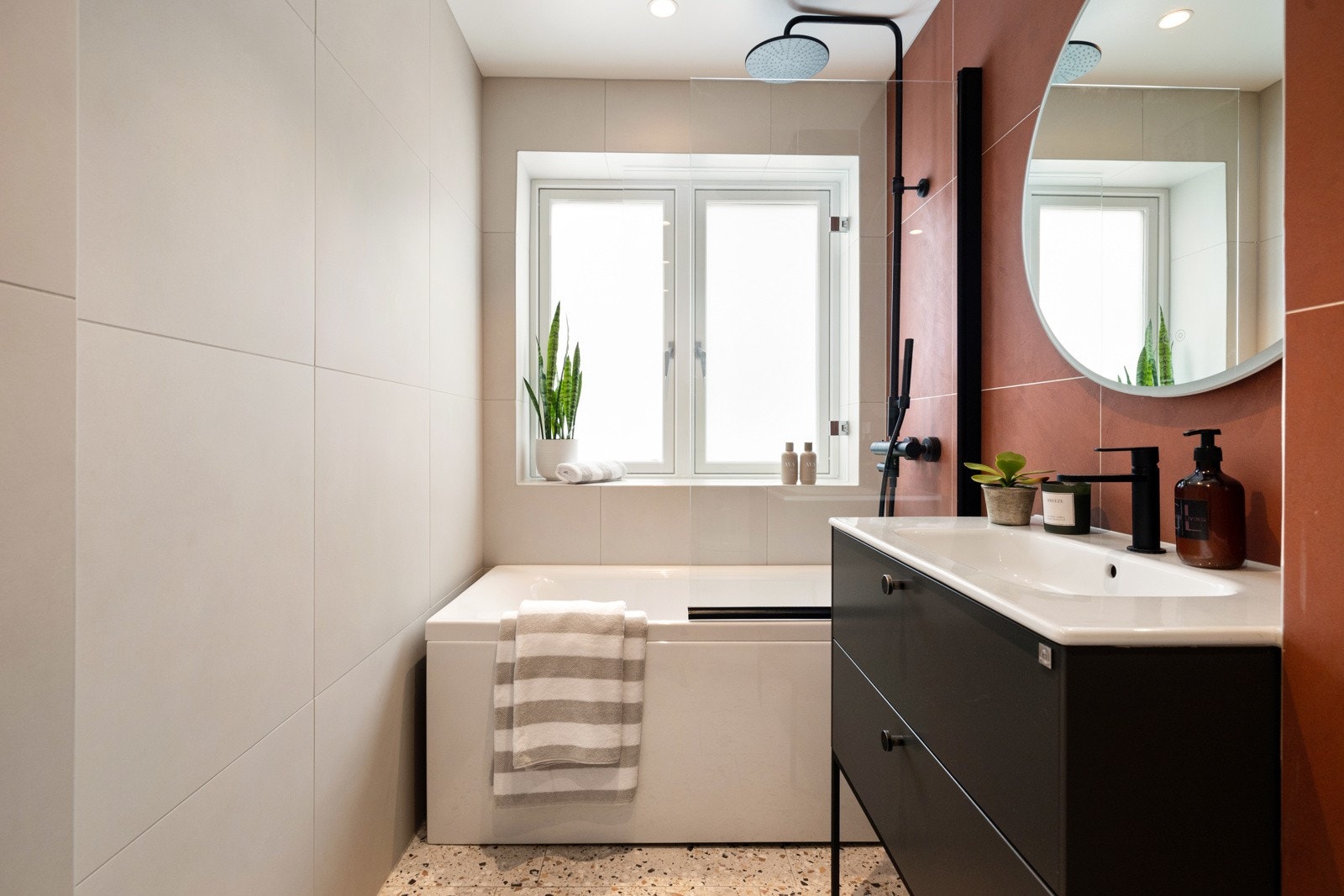 Badet har opplegg for vaskemaskin og et badekar med både regnfalls- og håndholdt dusj sørger for ekstra velvære Galleribilde