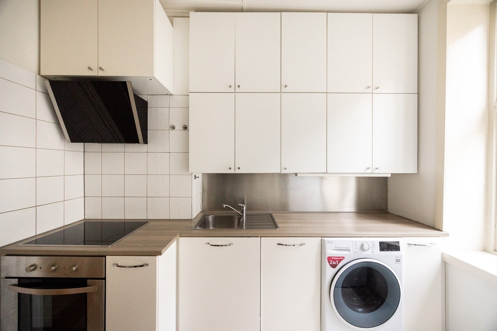 - Kjøkkeninnredning med glatte fronter og laminat benkeplate med nedfelt vask. Opplegg for vaskemaskin - Galleribilde