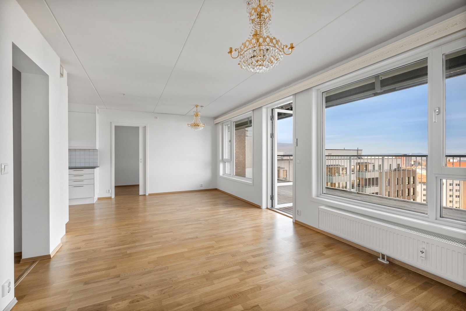 Stor stue med delvios åpen kjøkkenløsning og utgang til terrasse. Galleribilde